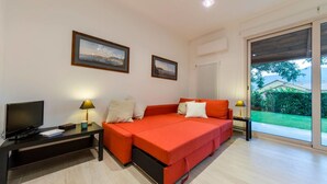 A modern bedroom with a bed, a TV, and two bedside tables with lamps. - JOIVY Golf Garlenda - Charming Villa Guest House (Garlenda)