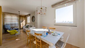Un coin repas avec une table, des chaises et une cage à oiseaux.