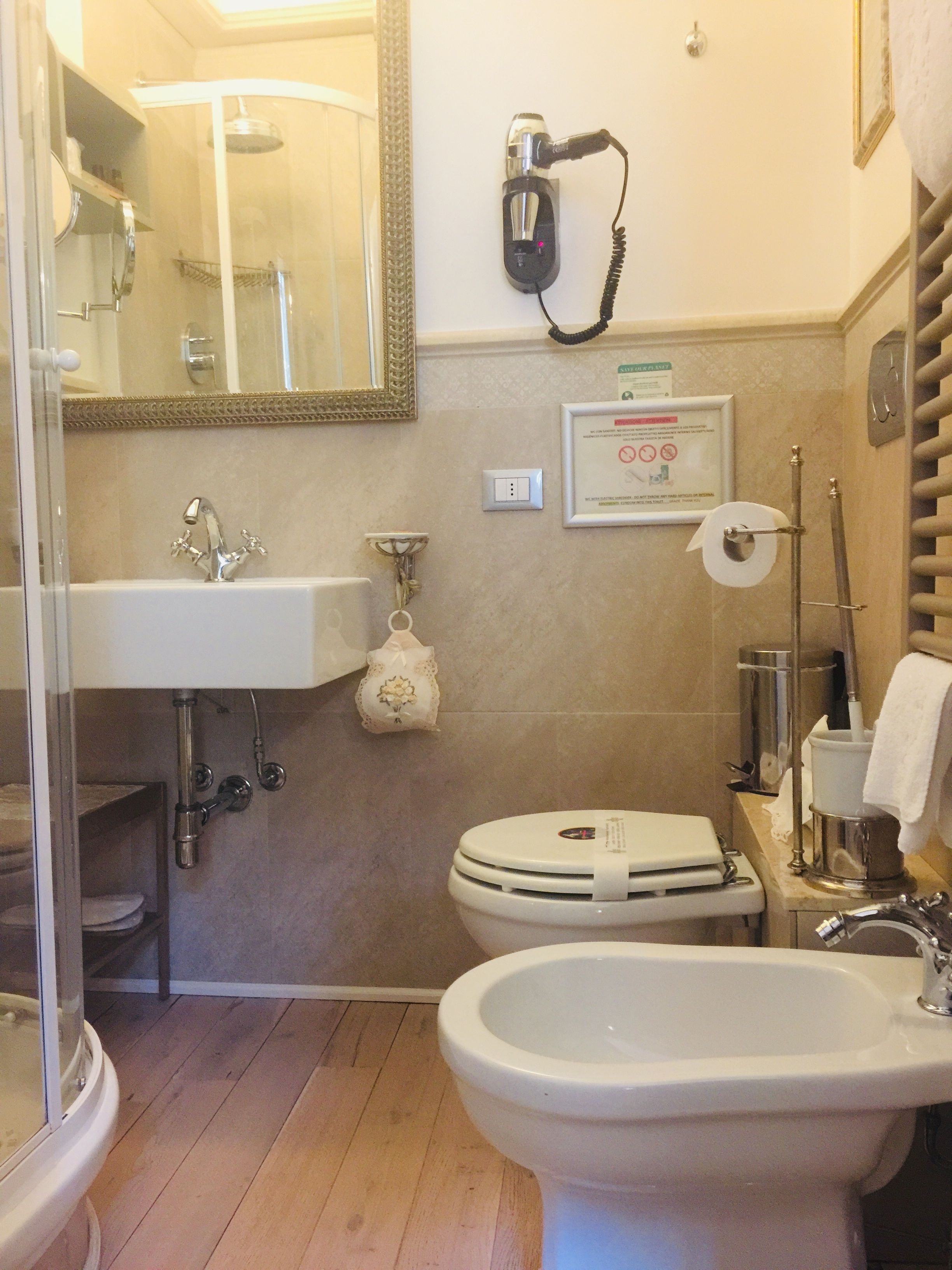 Un baño con lavamanos, bidé, inodoro y asiento de bidé.