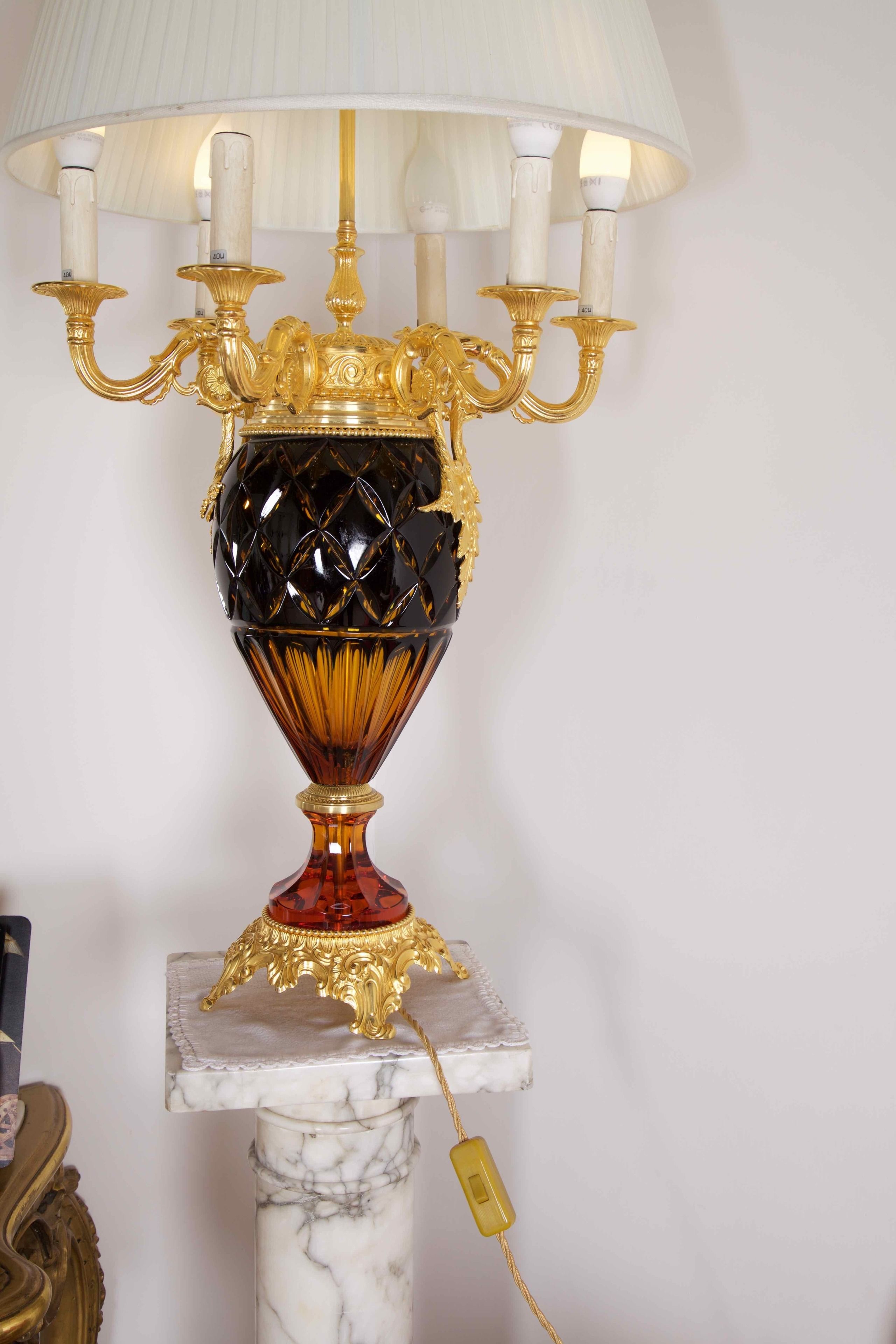 A table lamp with a gold base and a marble pedestal.