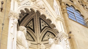 A detailed stone facade with intricate carvings and statues.