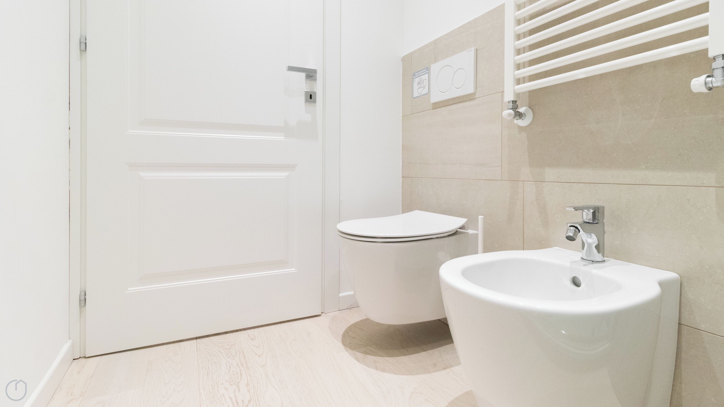 A modern bathroom with a toilet, bidet, and sink.