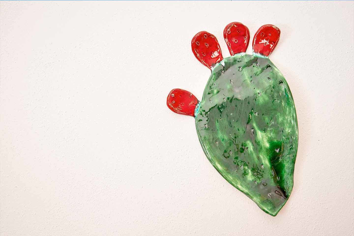 Un objeto con forma de cactus, con colores rojo y verde.