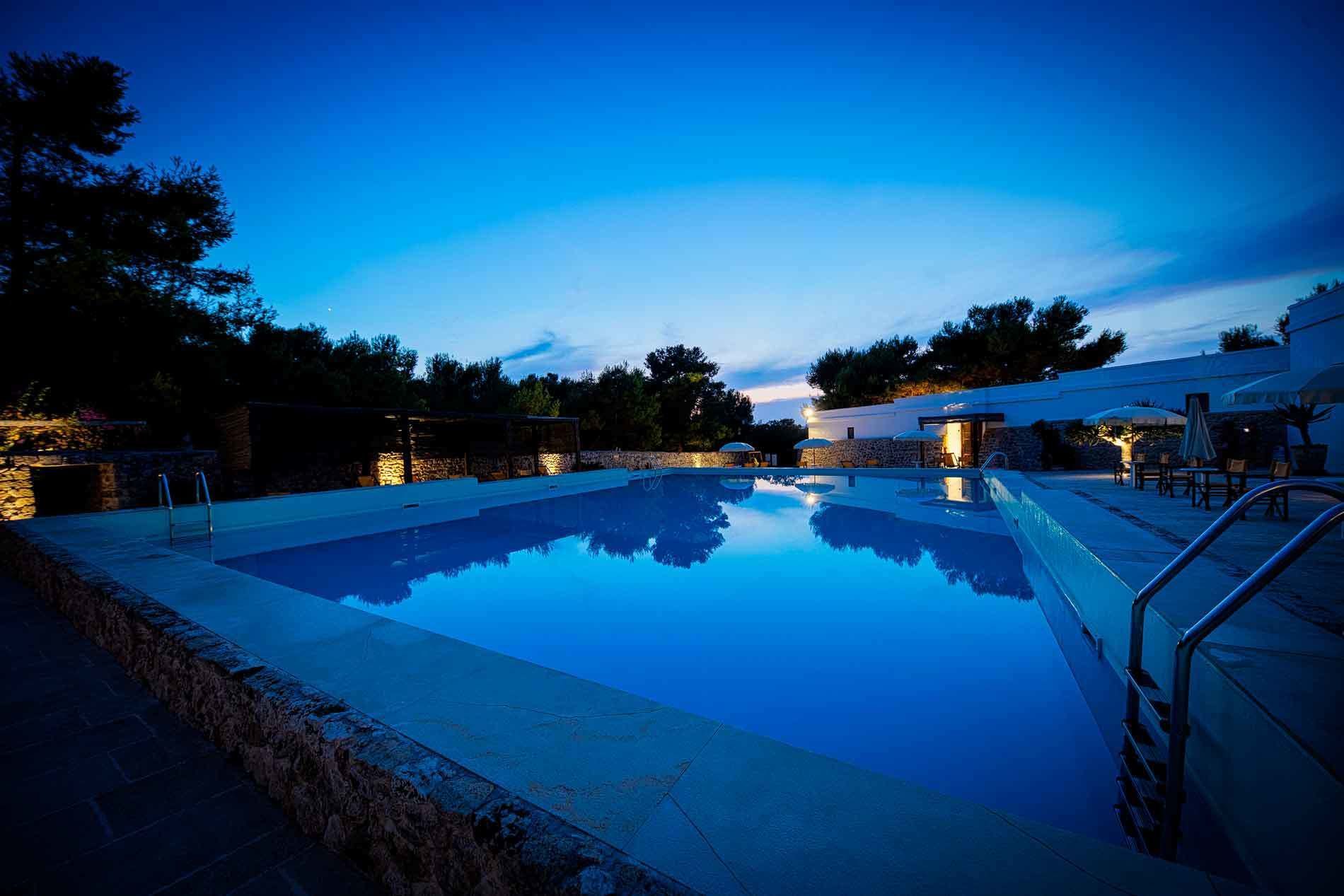 Ein Pool mit einer Steinmauer und einer Steintreppe, die zum Wasser hinabführt.