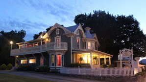 Un grand bâtiment à deux étages, doté d’un balcon et d’une véranda, qui ressemble probablement à un hôtel ou à une auberge, et sur lequel on peut lire une enseigne indiquant qu’il se trouve dans le quartier de Menandow.