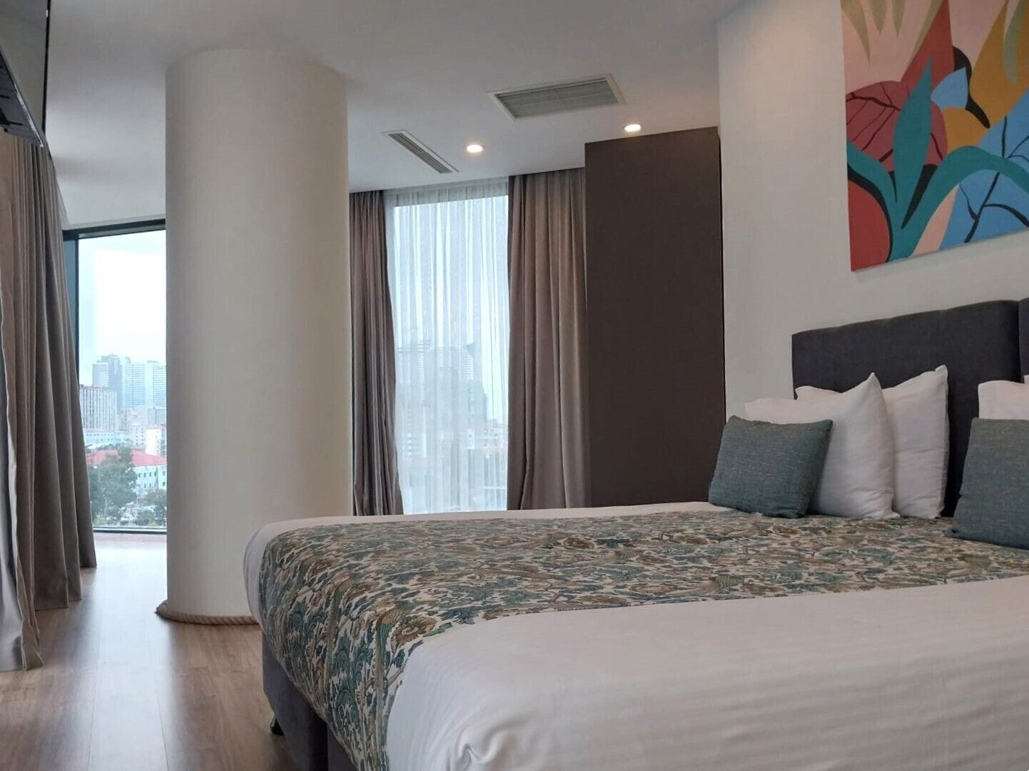 Quarto de hotel com uma cama grande, vista para a cidade e design moderno.