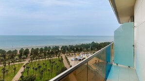 A balcony with a view of the beach and palm trees. - Bellevue Residence Suites (Batumi)