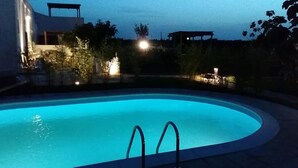 A swimming pool at dusk with a clear view of the pool's edge and a set of stairs leading into the water. - Casale alle Vigne (Nardò)