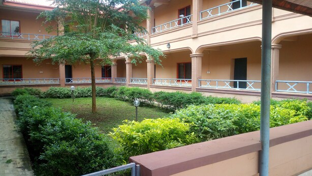 Un patio con un árbol, una fuente de agua y un edificio con balcones.