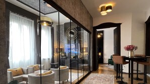 A modern living room with a sofa set, a dining area with a table and chairs, and a large mirror reflecting the room. -  Smart Hotel Budapest (Budapest)