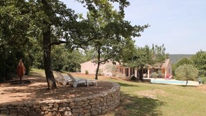 A stone-walled outdoor area with lounge chairs and a swimming pool. - Quiet villa with pool (Saint Martin de Pallières)