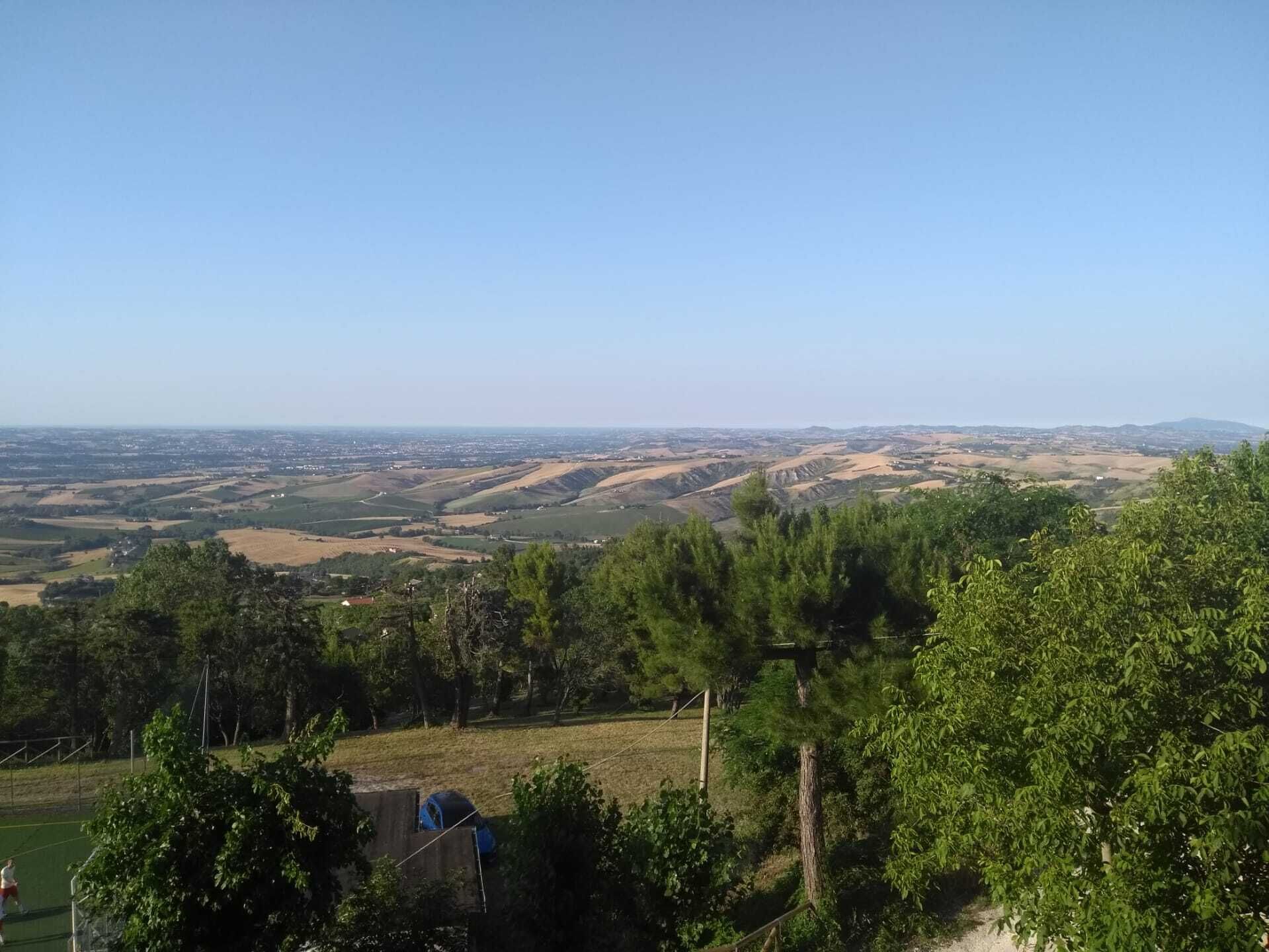 A panoramic view of a hilly landscape with a clear sky.