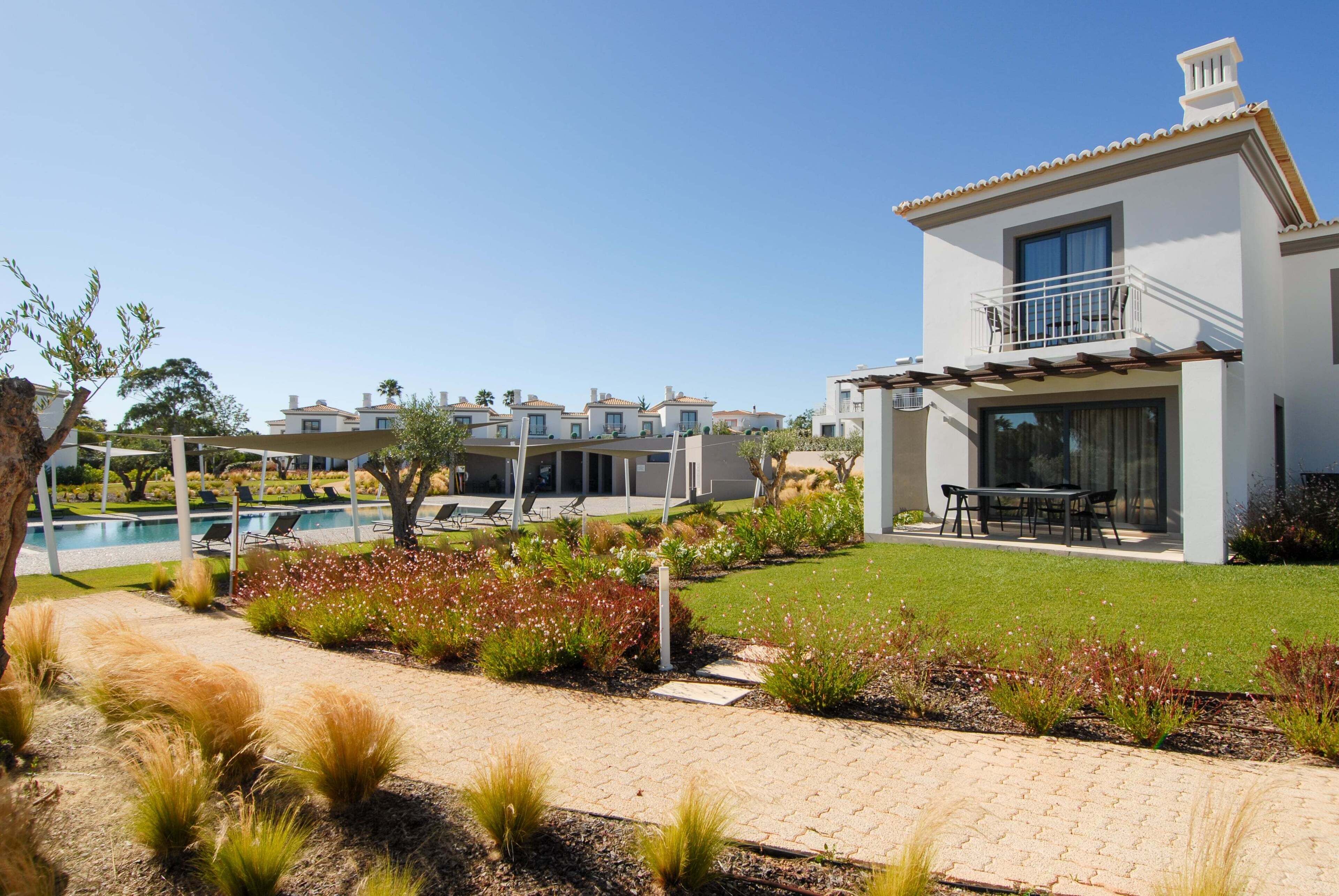 A modern building with a balcony and a pool area.
