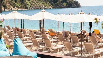 Playa privada, camastros, sombrillas y bar en la playa