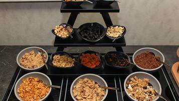Una mesa de bufé con diferentes alimentos dispuestos en recipientes.