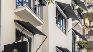 Un immeuble à plusieurs étages doté de balcons, d’une enseigne indiquant « ONIRO CITY ATHÈNES » et de climatiseurs.