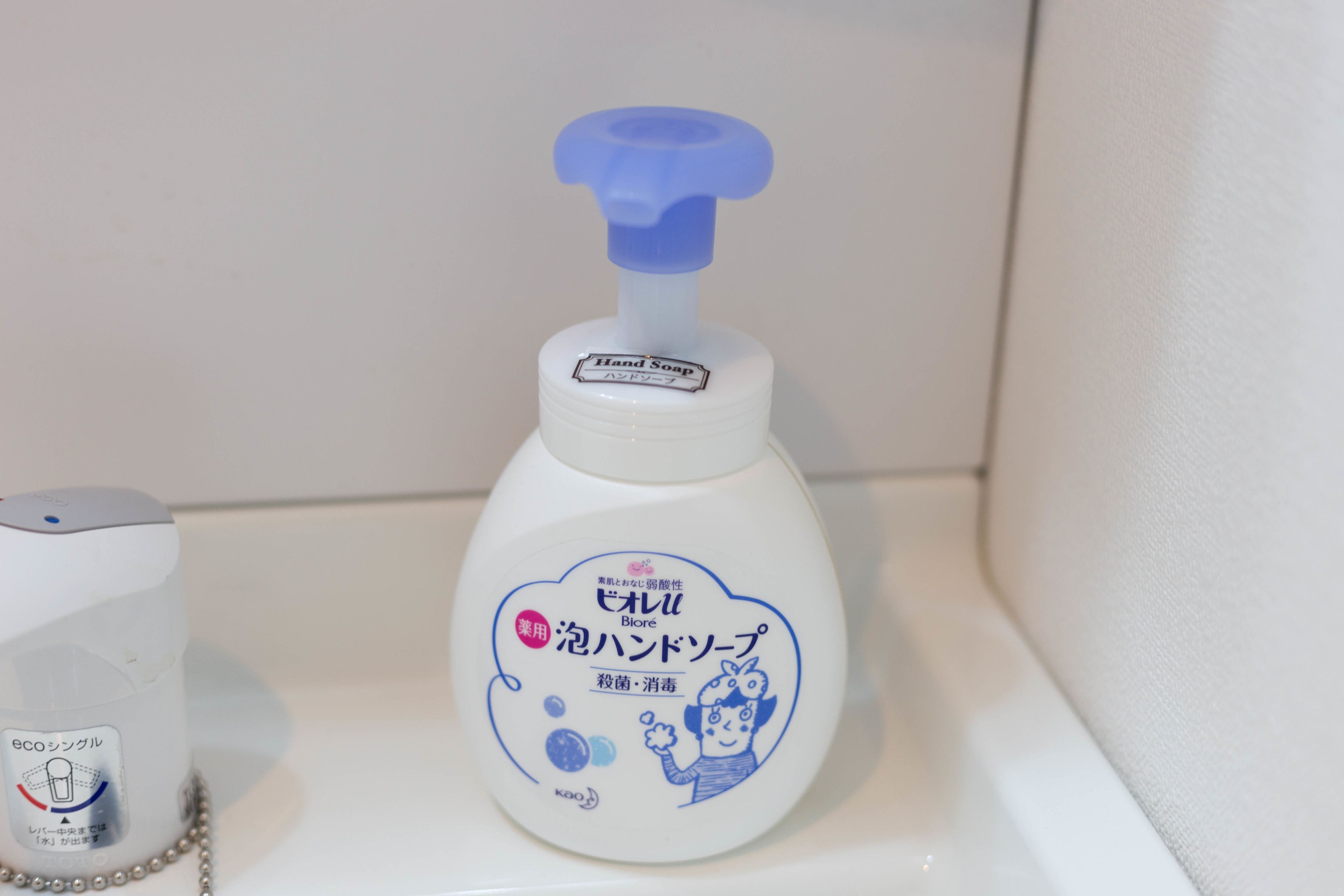 A bottle of hand soap with a pump dispenser on a white surface.