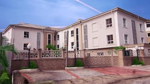 A multi-story residential building with a gated entrance, a driveway, and a well-maintained lawn. - Olive Branch Hotel (Port Harcourt)