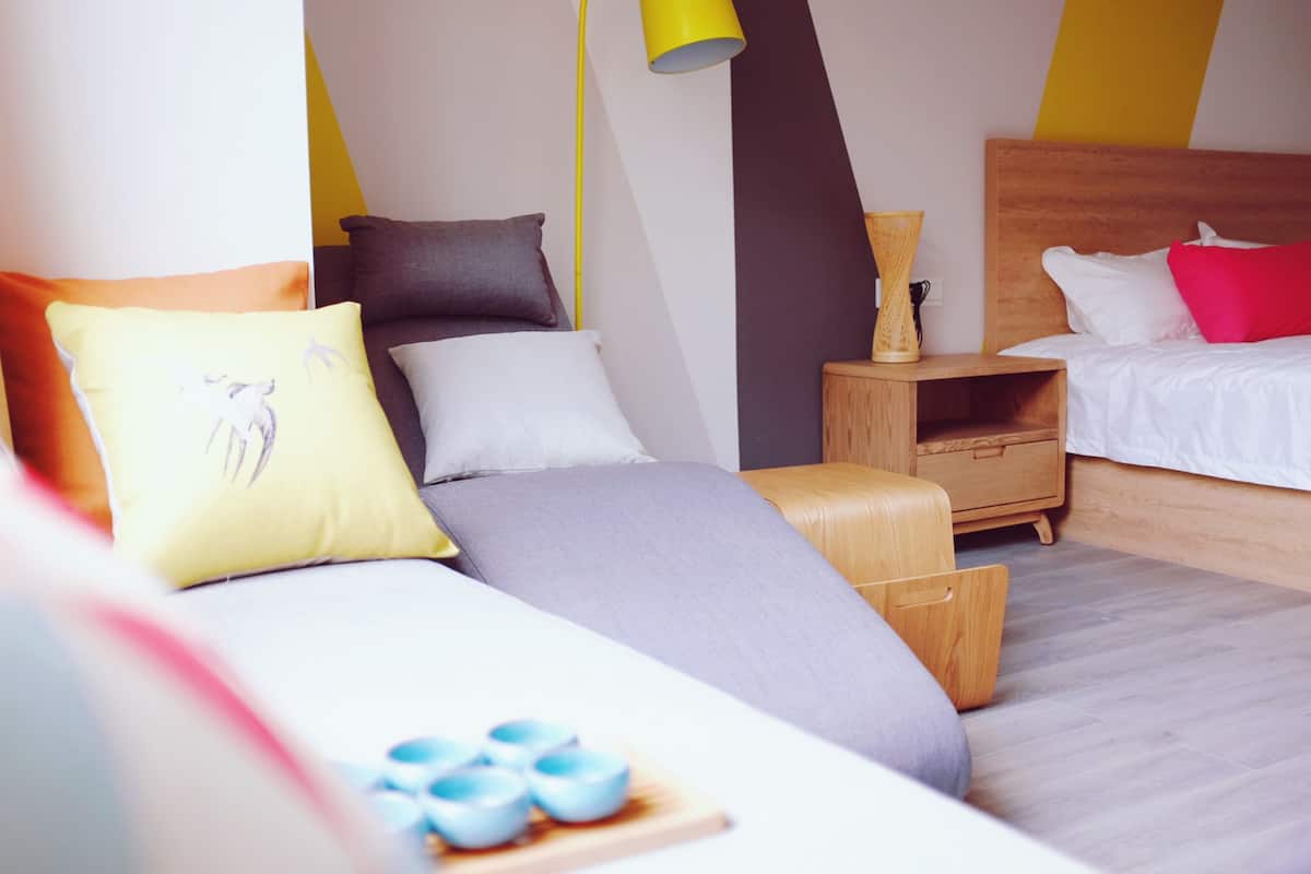 A modern bedroom with a bed, bedside tables, and a nightstand.