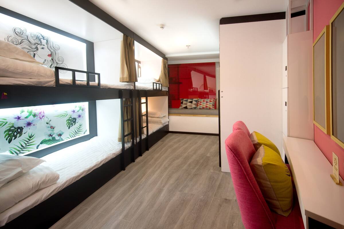 A room with bunk beds, a desk, and a wardrobe.