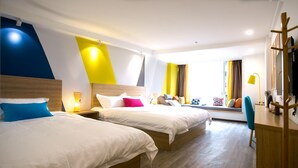 Habitación de hotel con dos camas, cabecera de madera, ventana con vistas y un escritorio con una silla.