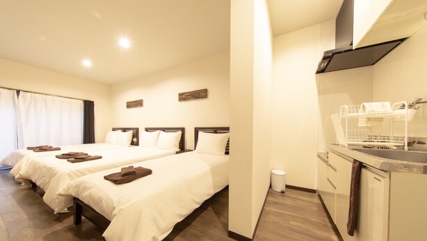 A hotel room with two beds, a kitchen area, and a bathroom. - Guest House ICHIKA (Kyoto)