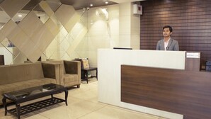 Et receptionområde med moderne design, med en receptionsdisk, en sofa og et sofabord.