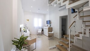 A modern, well-lit living area with a staircase, a dining area, and a kitchen. - Imera B&B (Favignana)
