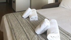 Une chambre d’hôtel avec un lit, une porte de salle de bain et un couloir.