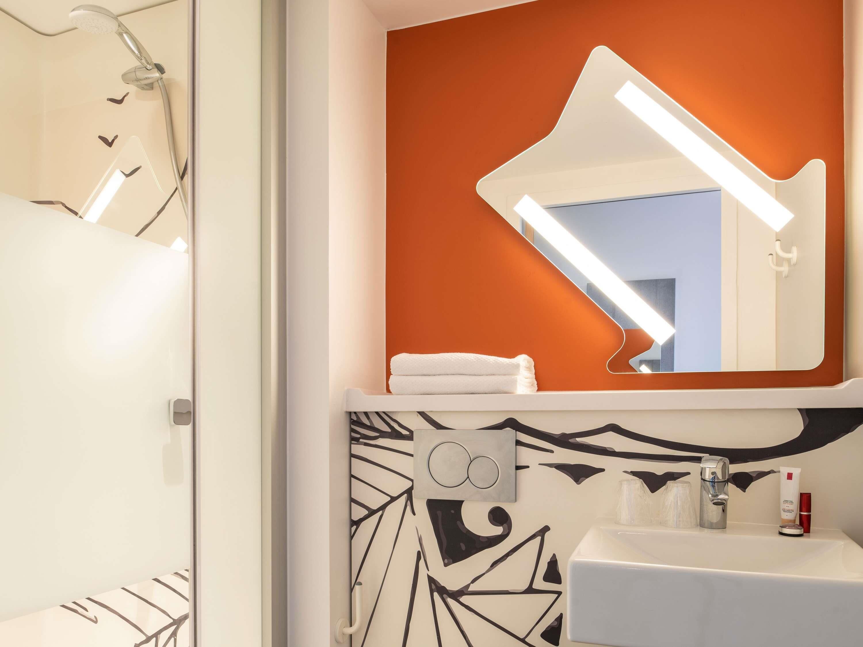 Un baño con ducha, lavabo y espejo.