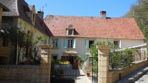 A traditional building with a red-tiled roof, a stone entrance gate, and a sign indicating it is a hotel. - Gîte 5p, 3*, Lascaux Périgord Noir, wifi parc Spa piscine chauf ok dog & cat (Montignac-Lascaux)