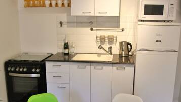 Departamento, vista a la ciudad | Cocina privada | Refrigerador con congelador, microondas, horno y parrilla de estufa