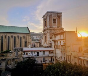 A historic building with a prominent tower and a church with tall windows. - Le Ninfe Luxury Rooms (Naples)