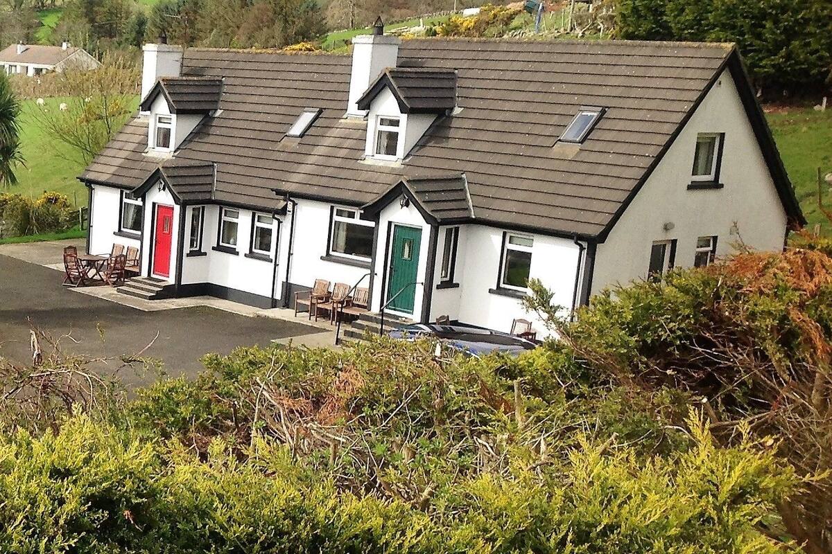 Une rangée de maisons blanches aux toits sombres, chacune ayant une porte de couleur différente.