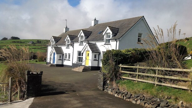 A white building with a grey roof, a yellow door, and a blue door. - Beachview Cottage (Ballymena)
