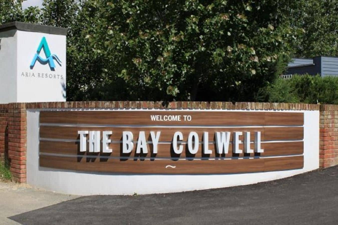 Ein Willkommensschild für The Bay Colwell, darüber das Logo.