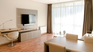 A modern living room with a flat-screen TV, a dining area, and a sofa. - Hotel Boutique Sofia Soberana (Bahia Blanca)