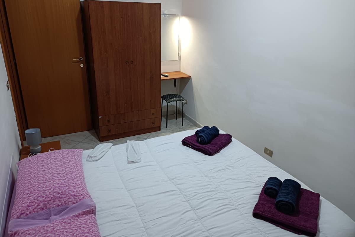 Une chambre d’hôtel comprenant un lit, une armoire, un bureau et une chaise.