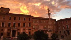 A historic building with a central courtyard, a statue, and a fountain. - Ostello Palazzo Nizza (Massa)