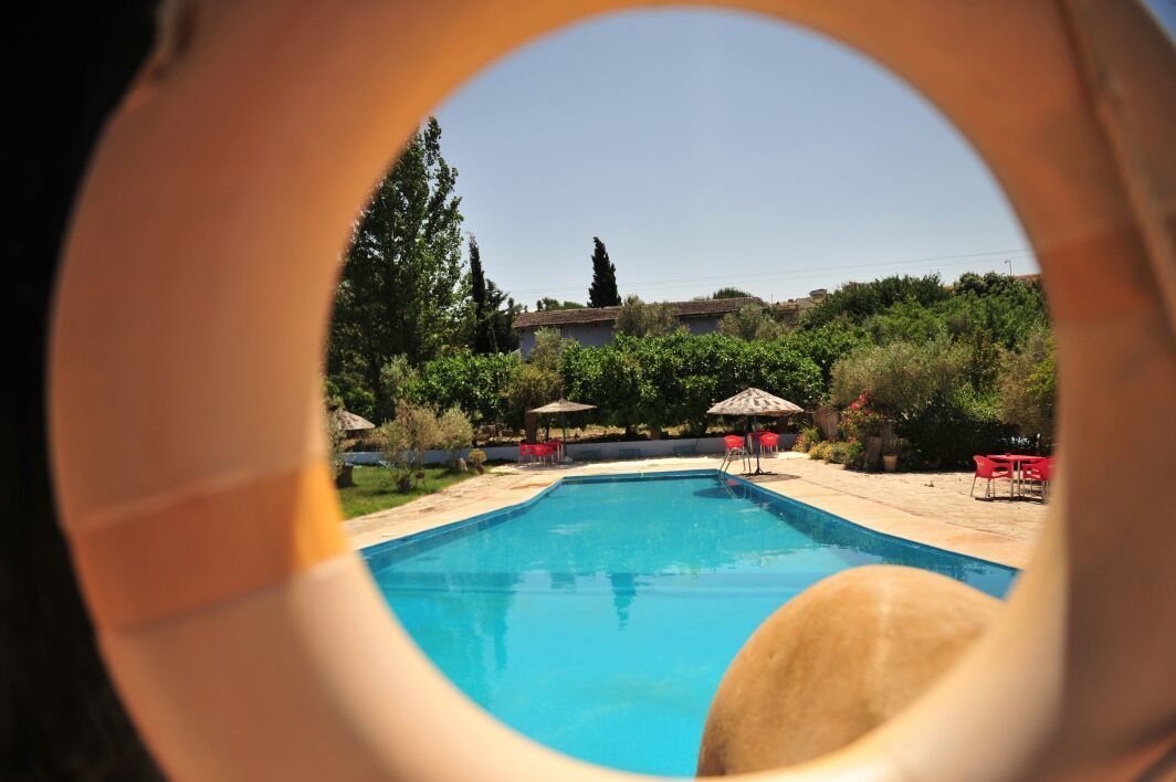 Una piscina al aire libre de temporada, sombrillas, tumbonas