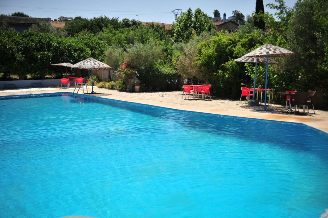 Una piscina al aire libre de temporada, sombrillas
