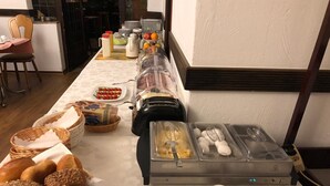 Ein reichhaltiges Buffet mit verschiedenen Speisen, darunter Brot, Obst und Getränke.