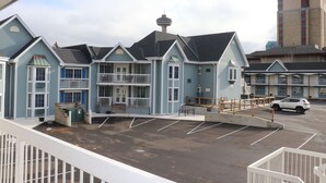 A hotel with a parking lot, a view of a tower, and a building with a unique architectural design. - Falls Lodge and Suites (Niagara Falls)