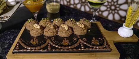 A dessert platter with sweets and a decorative chocolate design on a wooden board.