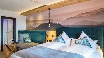 Ein Schlafzimmer mit zwei Betten, einer Holzbalkendecke, einer Berggirlande und einer Duschkabine.