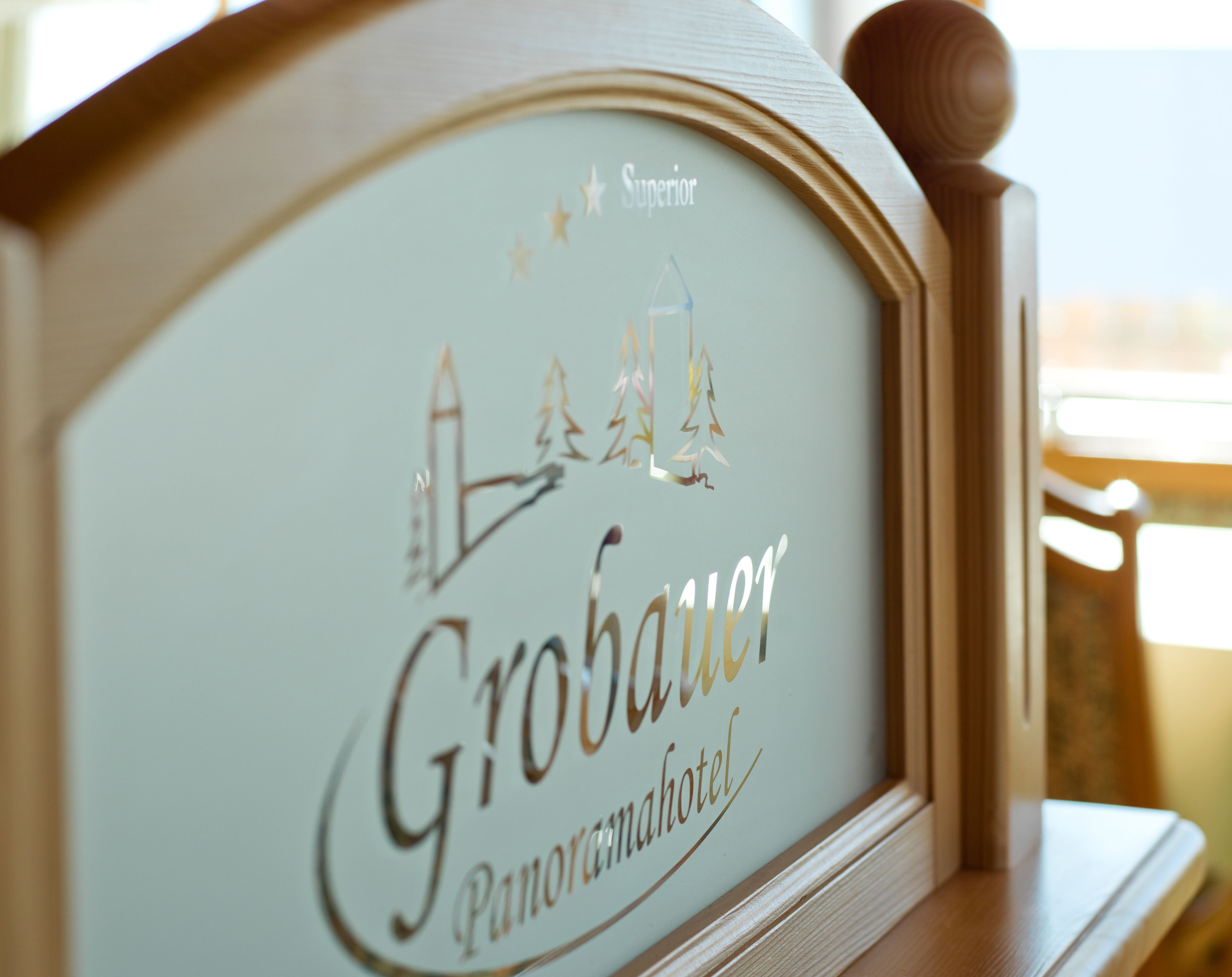 A framed sign with the text "Großaufer Panoramahotel" and decorative elements including stars and trees.