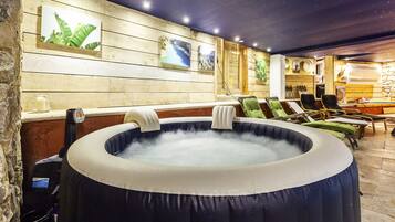 Relax in a hot tub surrounded by lounge chairs and framed pictures, set against a starry ceiling.