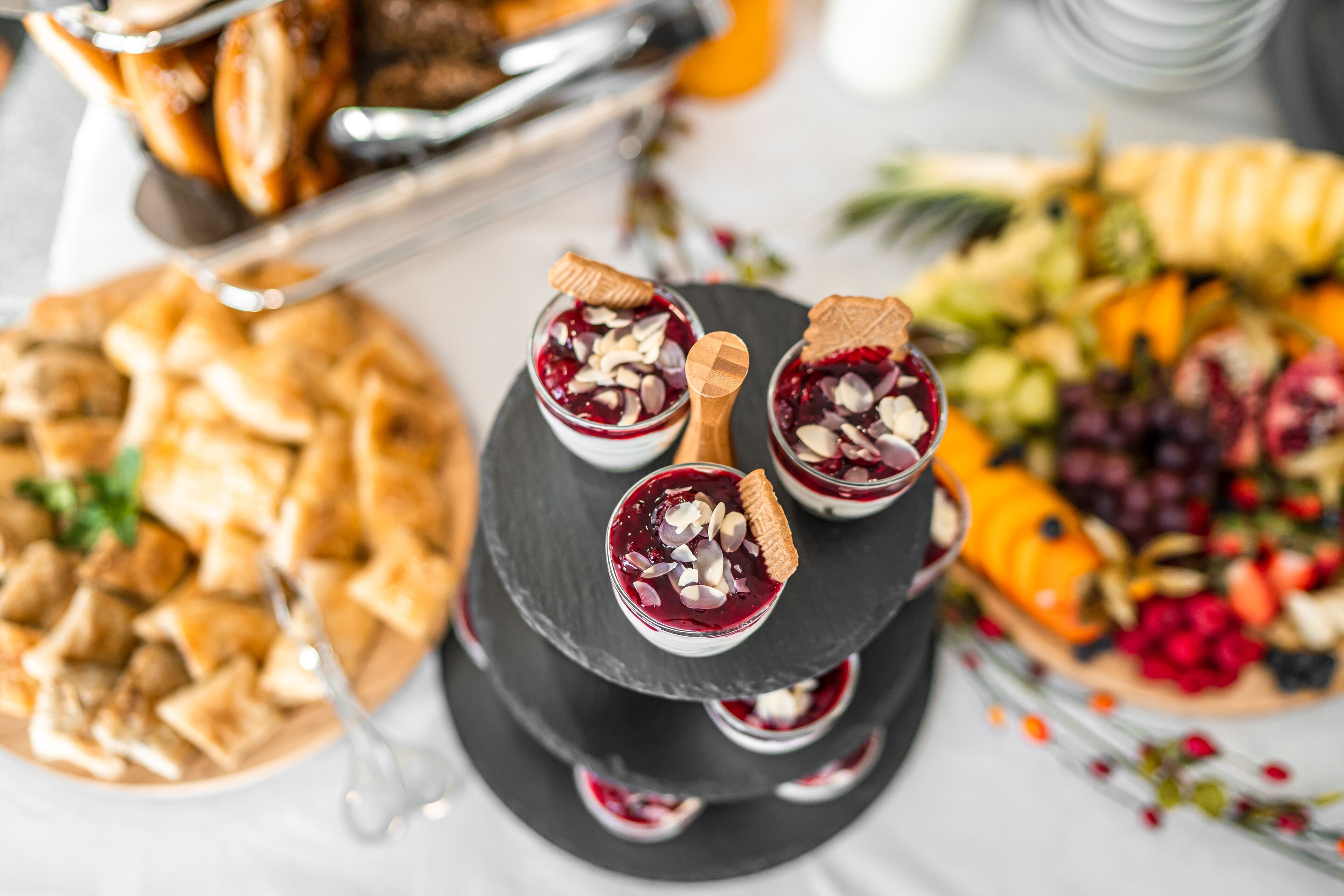 A multi-tiered dessert stand with various desserts and a fruit platter.