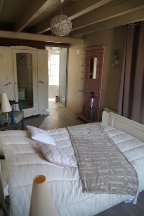 Un dormitorio con cama, armario y espejo.