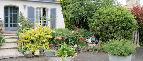 A house with a garden, a stone wall, and a satellite dish.